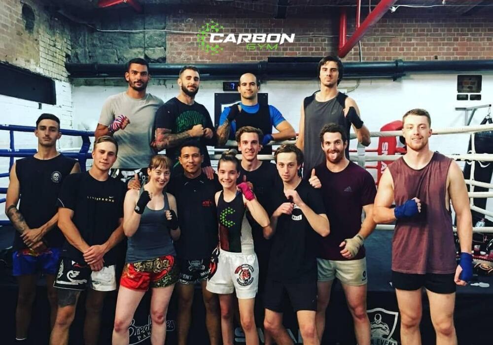 Muay Thai class posing together by the boxing ring at Carbon Gym Geelong