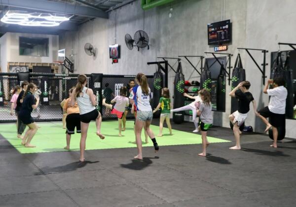 Group of kids doing warm-up drills during a martial arts class on the mats at Carbon Gym Geelong