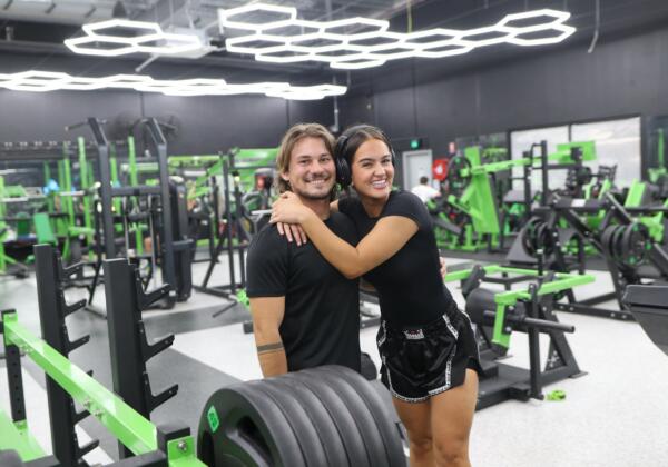 Two smiling members on the strength floor surrounded by weights equipment at Carbon Gym Geelong