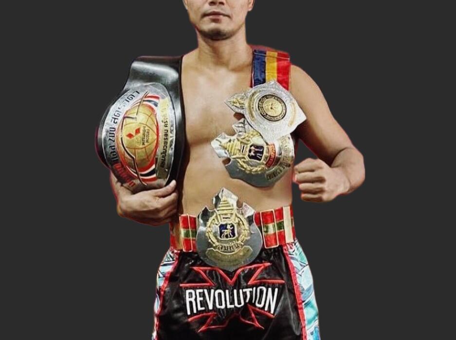 Muay Thai champion Sagadphet holding his championship belts, featured at Carbon Gym Geelong