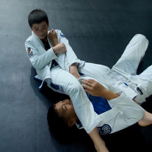 Two boys in white gis training Brazilian Jiu-Jitsu in the kids BJJ class at Carbon Gym Geelong