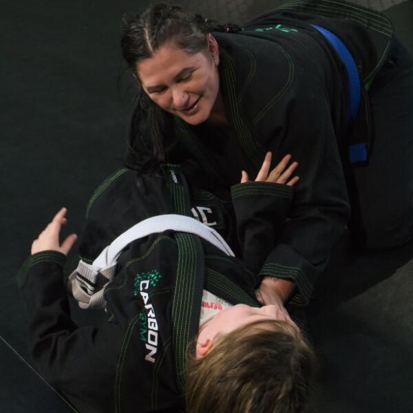 BJJ for beginners in Geelong: a woman training Brazilian Jiu-Jitsu with a partner at Carbon Gym