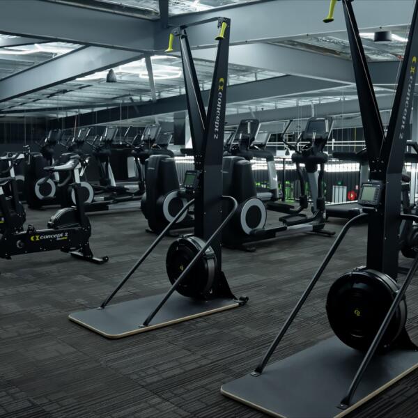 Functional training area showing rowing machines and assault bikes with treadmills and ellipticals in the background.