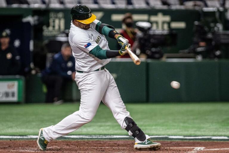 Darryl George swinging a bat for Australia at the Tokyo Dome during the 2023 World Baseball Classic