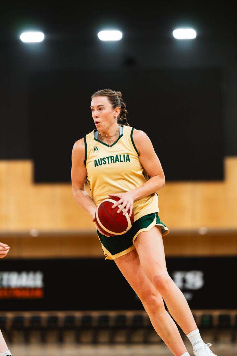 Sara Blicavs dribbling a basketball mid-game in an Australia representative jersey