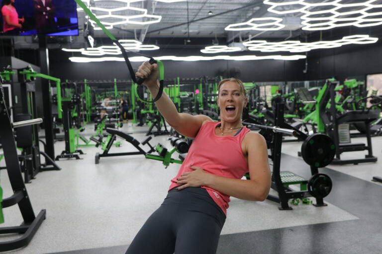 Sara Blicavs smiling while performing a cable pull exercise at Carbon Gym