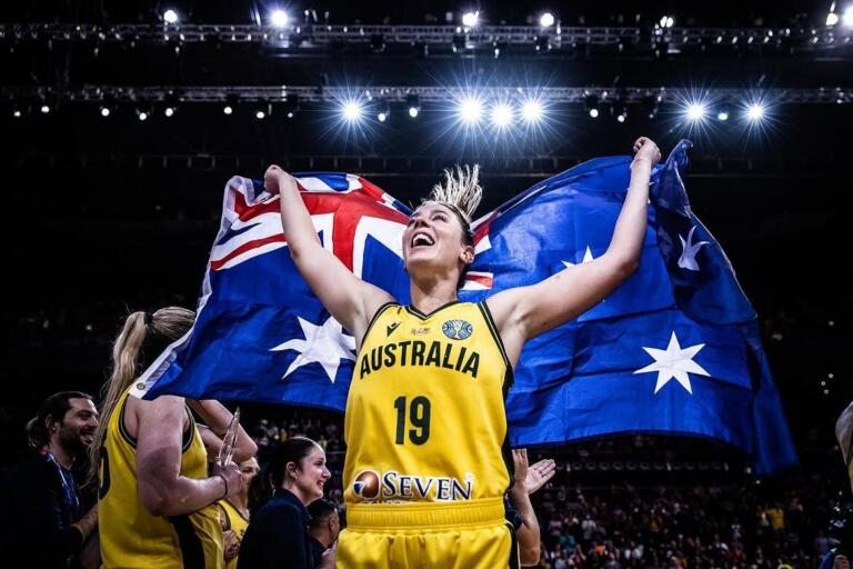 Sara Blicavs celebrating with an Australian flag draped around her shoulders in an Opals basketball jersey