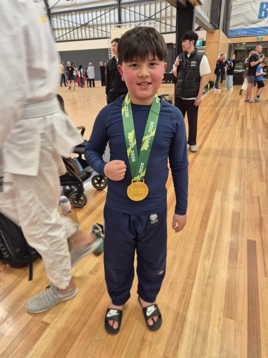 Young Carbon Gym BJJ competitor in a navy rash guard wearing a gold medal from the Regional Victoria Jiu Jitsu Championships 2026 in Torquay