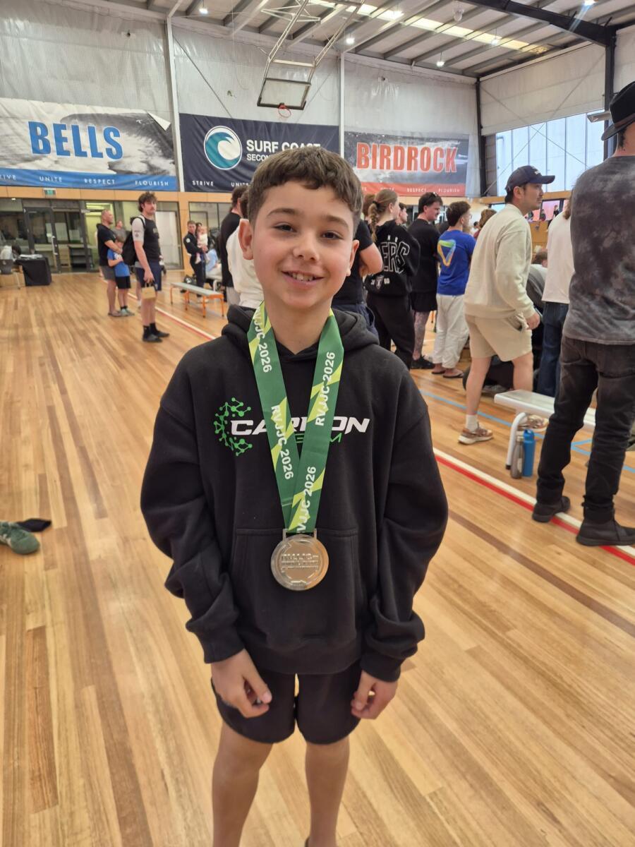 Smiling young Carbon Gym BJJ competitor in a Carbon hoodie wearing a silver medal from the Regional Victoria Jiu Jitsu Championships 2026