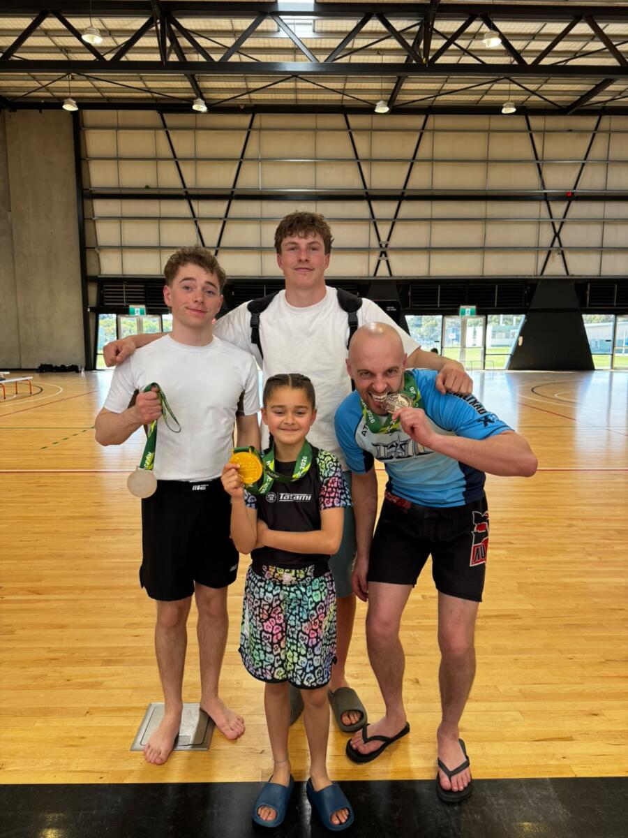 Young Carbon Gym BJJ gold medalist with three teammates and coaches holding medals at the Torquay jiu jitsu championships